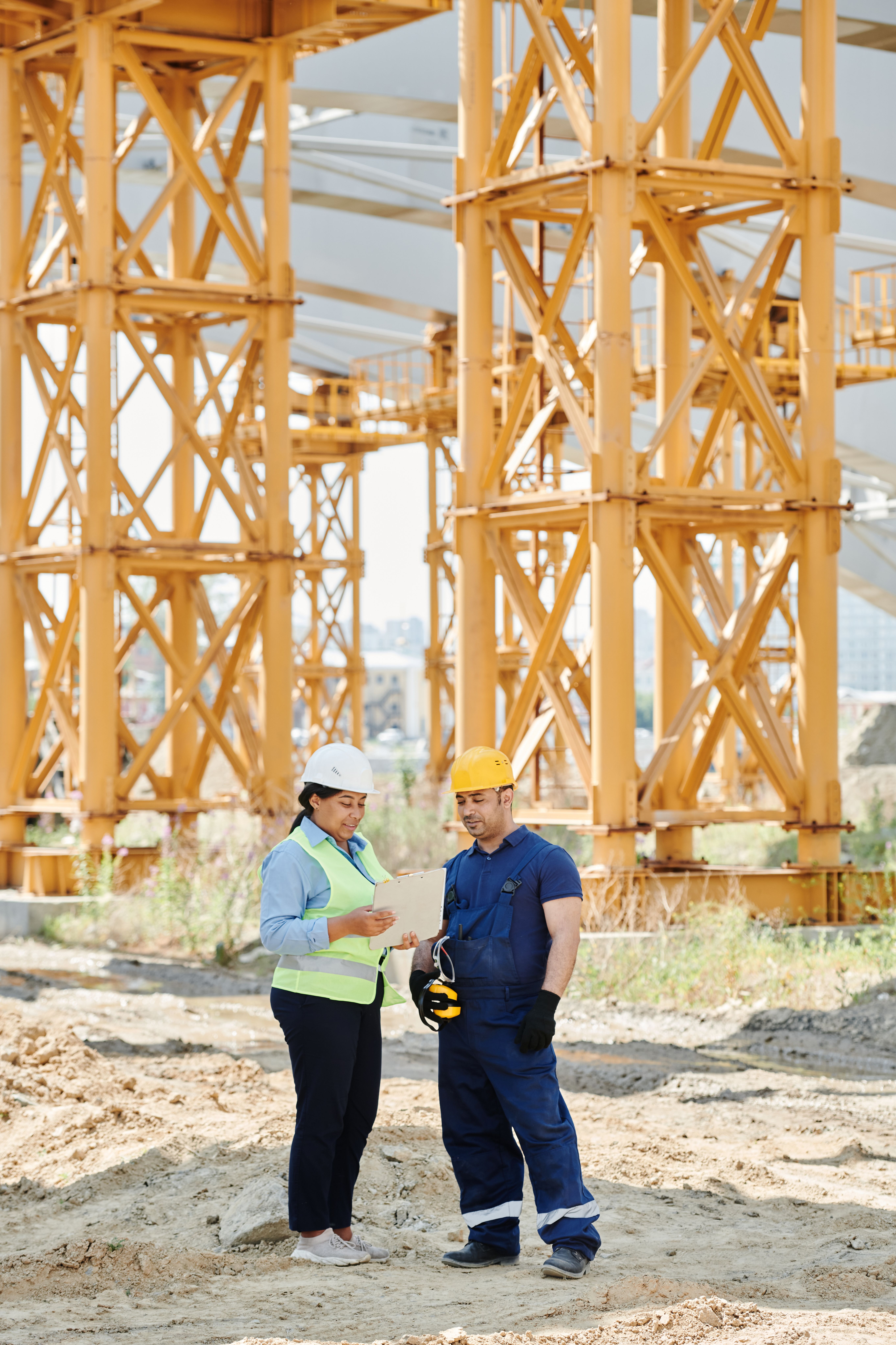Safety instructor reviewing site conditions with a worker on an active construction project